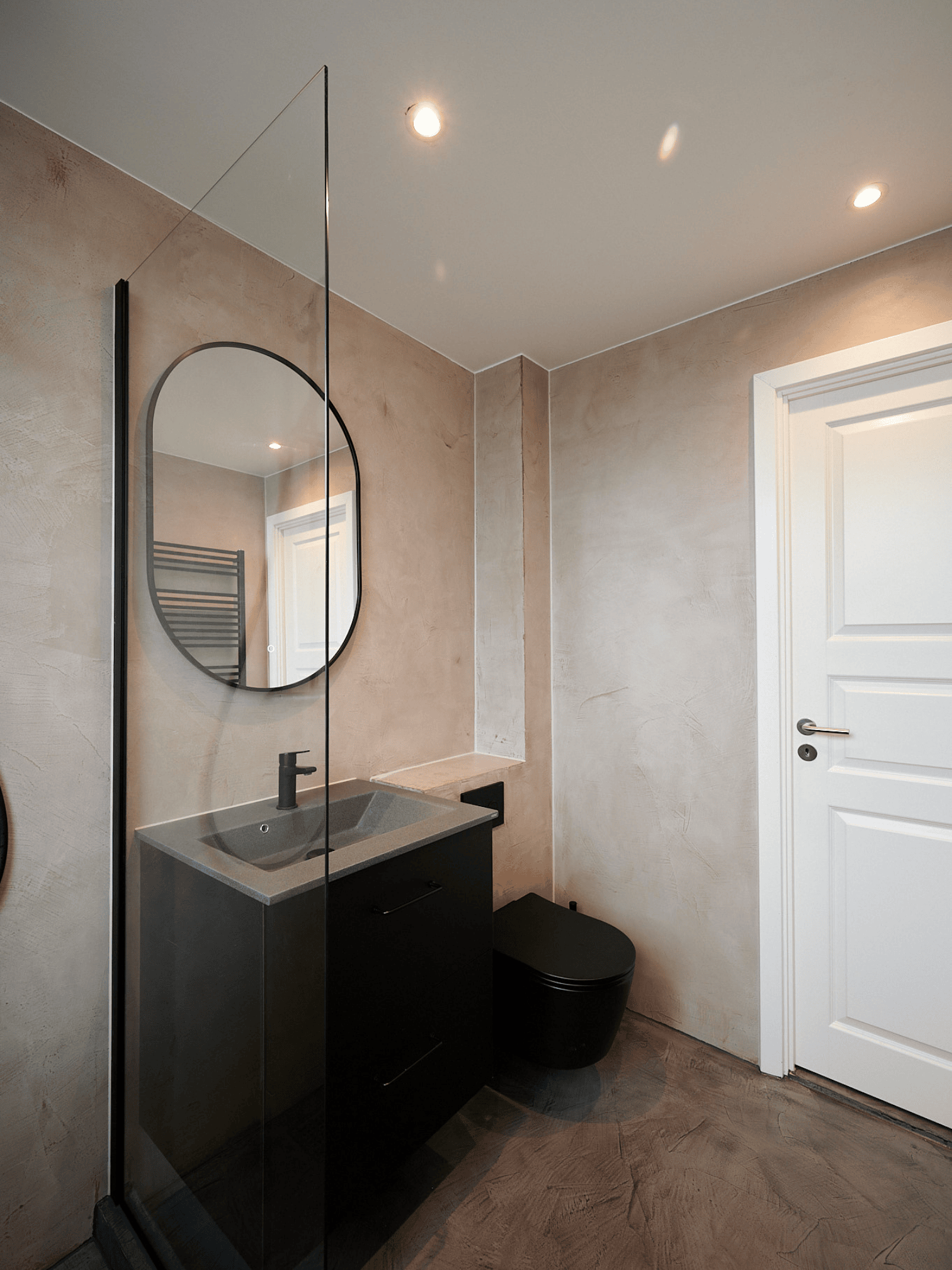 Microcement-toilet med spejl og sort vask
